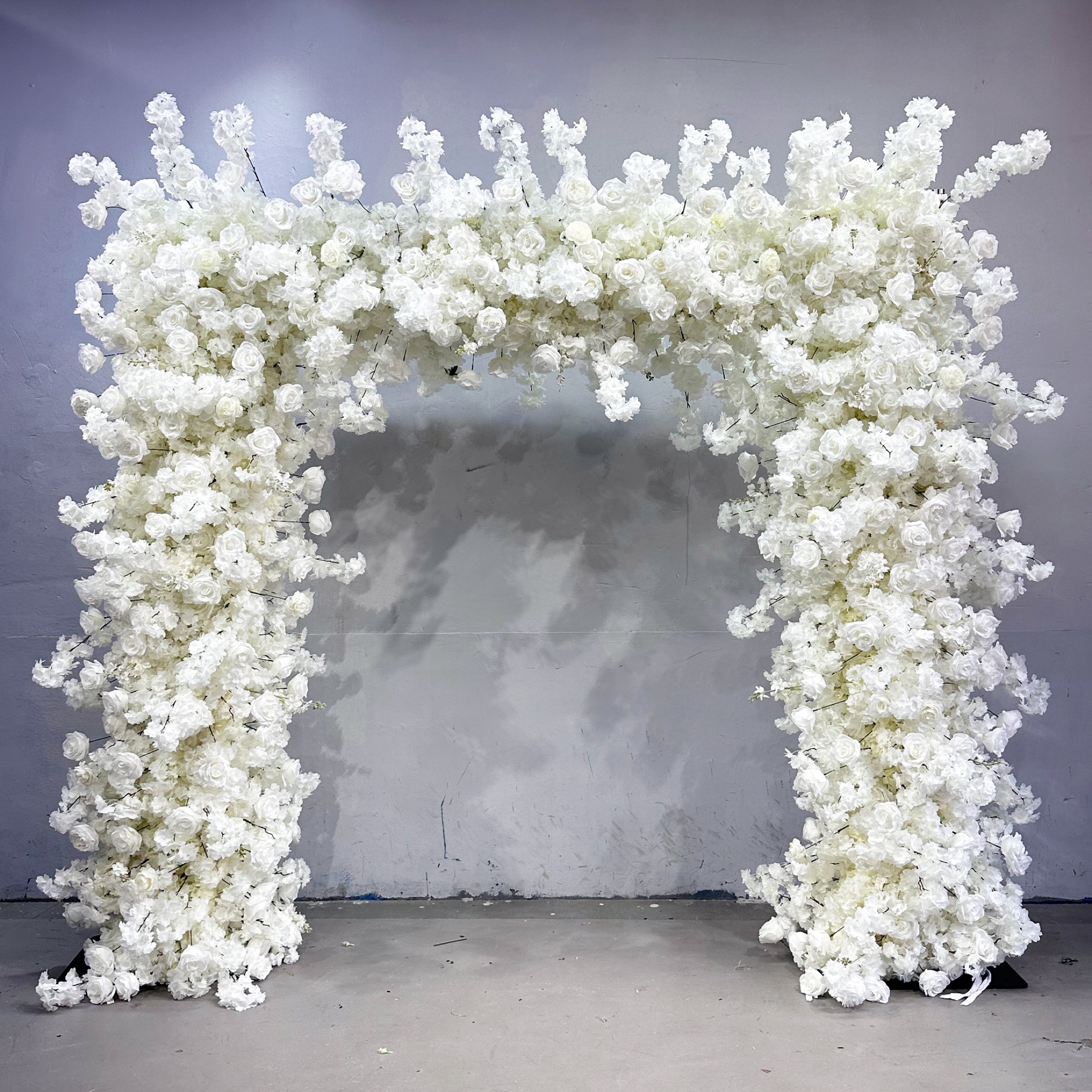 Square faux-flower arch filled with white roses and blossoms