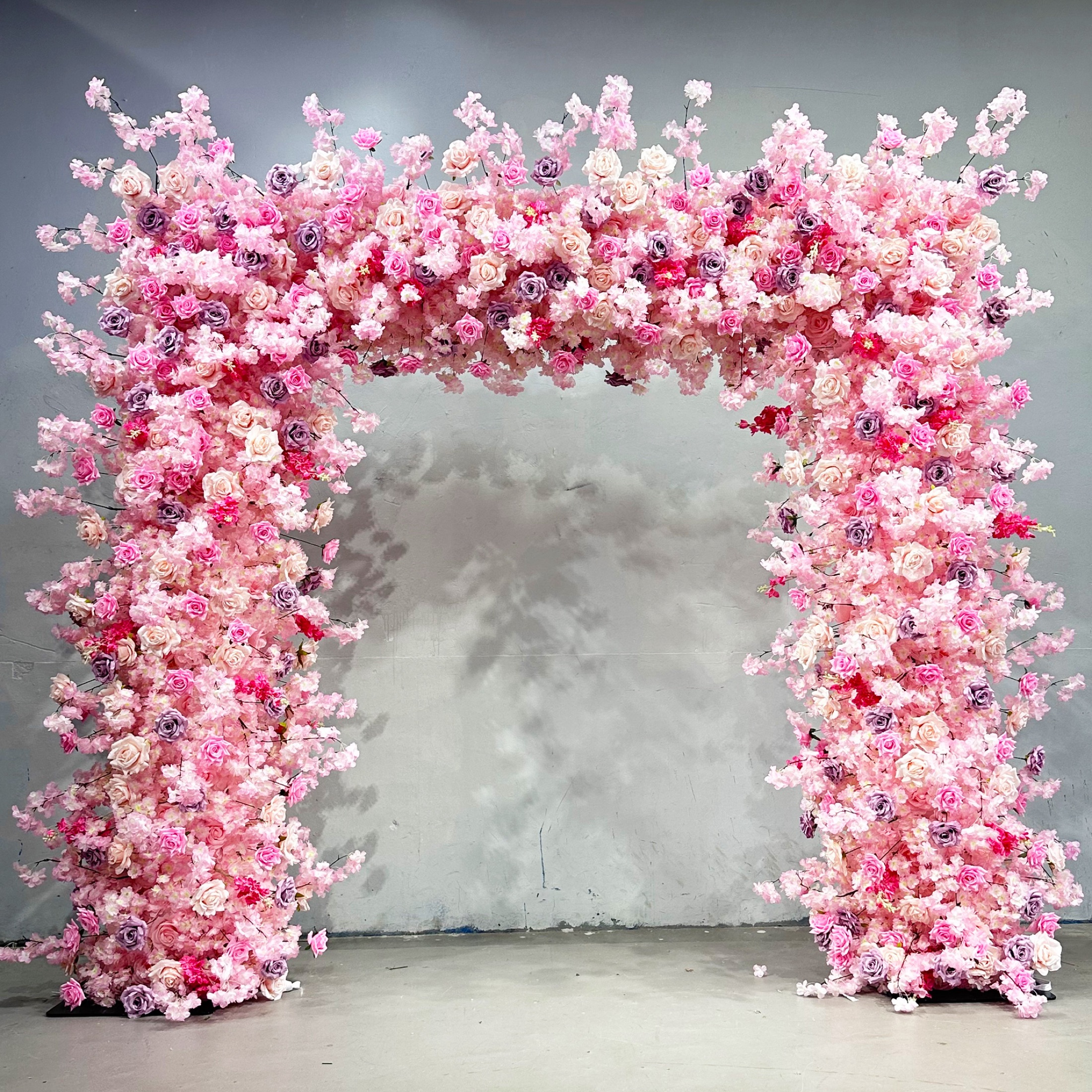 Square faux-flower arch with pink blossoms, roses and lavender accents