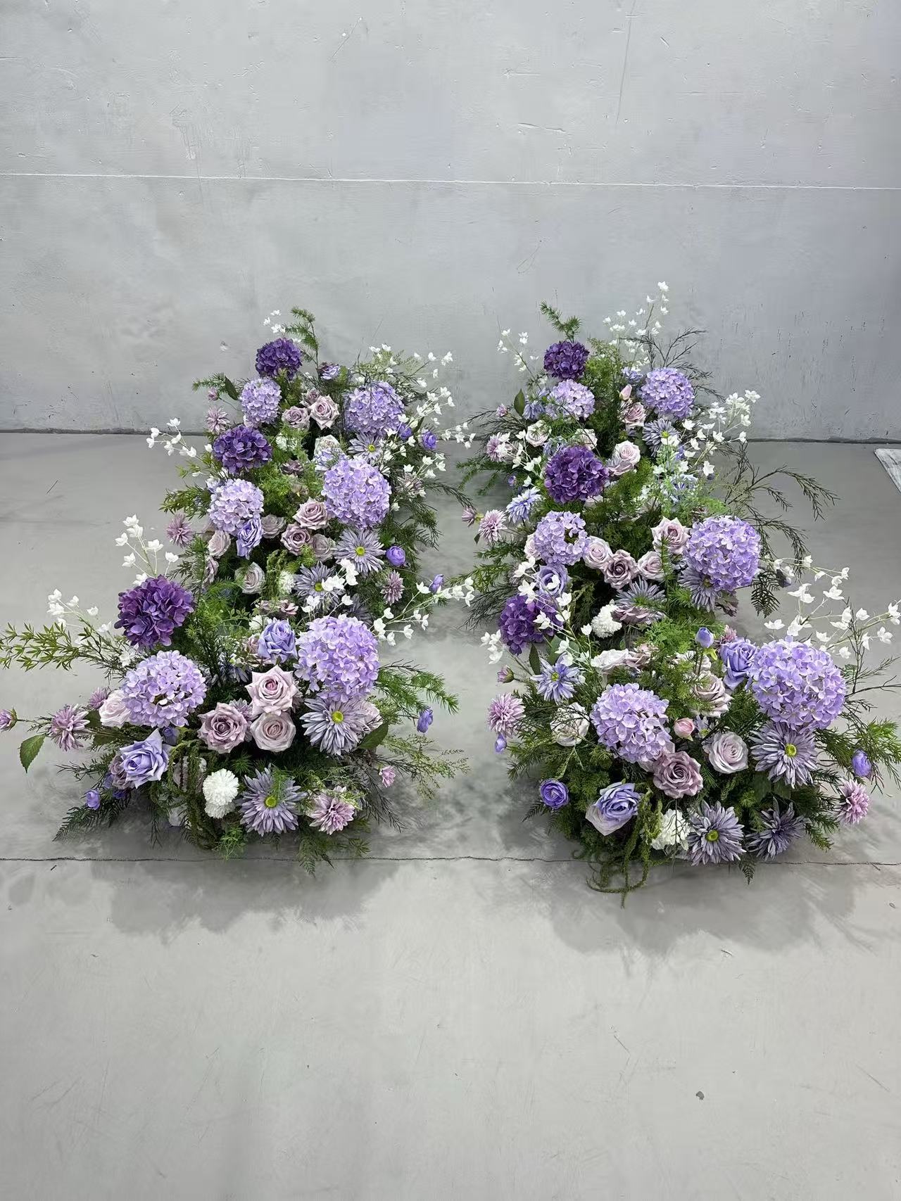 Purple faux-floral pillars arranged as lower ground pieces