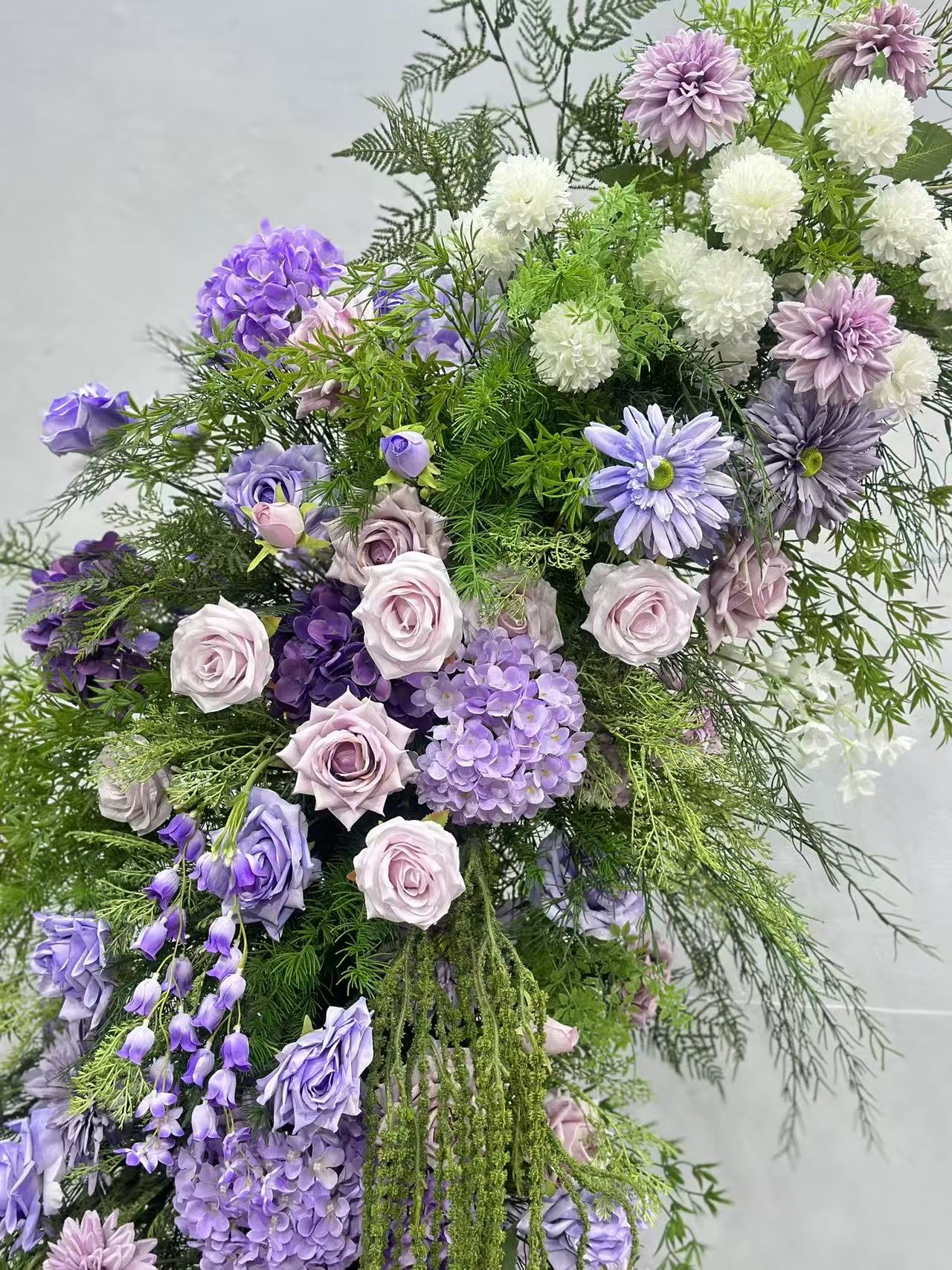 Close view of lavender roses, white mums and greenery